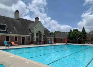 une grande piscine en face d'une maison dans l'établissement Beautiful Cozy 3-Bedroom Townhome Retreat, à Atlanta