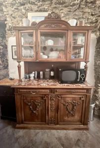 um armário de madeira com um micro-ondas e uma televisão em Via Liberale Sleeps 8 Isolabona Italy em Isolabona