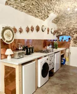 uma cozinha com um fogão e um lavatório em Via Liberale Sleeps 8 Isolabona Italy em Isolabona
