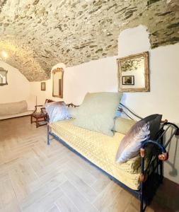 a couch in a room with a stone ceiling at Casa Valentino in Via Liberale Isolabona Sleeps 8 Isolabona Italy in Isolabona