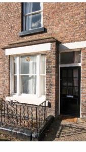 a window on a brick building with a bench at Liverpool in Woolton