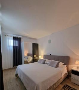 ein Schlafzimmer mit einem großen weißen Bett in einem Zimmer in der Unterkunft Villa Paola in Bol