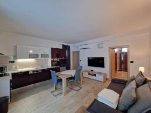 ein Wohnzimmer mit einem Sofa und einem Tisch sowie eine Küche in der Unterkunft Villa Paola in Bol