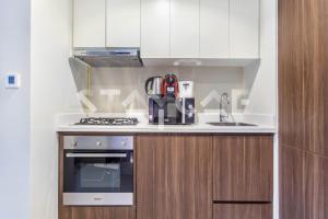 a kitchen with a stove and a sink at Staycae Holiday Homes - Reva in Dubai