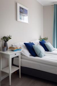 ein Bett mit blauen und weißen Kissen und einem Tisch in der Unterkunft Apartamenty-Kudowa z pięknym widokiem i balkonem in Kudowa-Zdrój