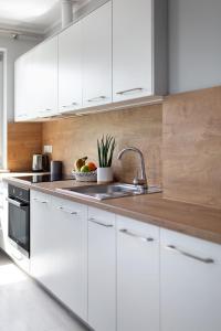 a kitchen with white cabinets and a sink at Apartamenty-Kudowa z pięknym widokiem i balkonem in Kudowa-Zdrój