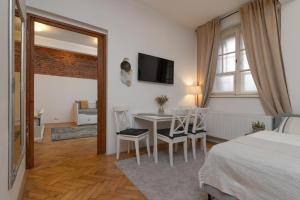 - une chambre avec un lit, une table et des chaises dans l'établissement Cozy Local Naplavka Apartments in Center, à Prague