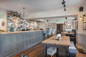 a bar in a pub with a wooden table and chairs at The Crown Hotel, Boroughbridge, North Yorkshire in Boroughbridge