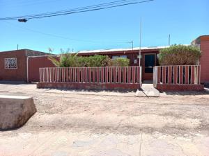 un bâtiment avec une clôture devant lui dans l'établissement Ckoinatur Hostel, à San Pedro de Atacama