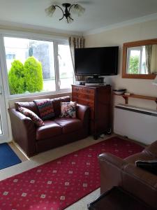 a living room with a couch and a flat screen tv at Freshwater Bay, 138 in Hodgeston