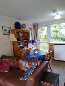 a living room with a leather couch and a table at Freshwater Bay, 138 in Hodgeston