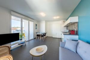 a living room with a couch and a table at Bluemary - Spacieux T3 Garage balcon in Lyon