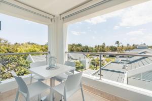 a white table and chairs on a balcony with a view at 1BR Apt at Green One in Muñoz