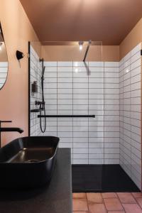 ein Bad mit einer schwarzen Badewanne und einer Dusche in der Unterkunft ARCA Resort 