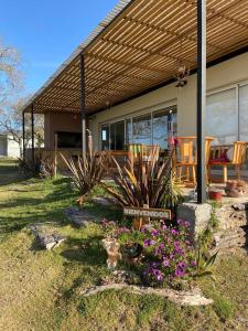 una casa con un porche con flores en el patio en Los colibries, en San Pedro 21 fotos más