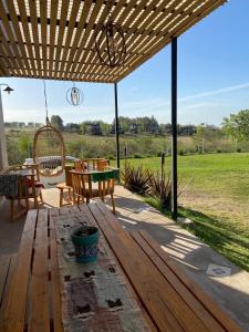 a patio with a wooden table and chairs and a bench at Los colibries in San Pedro