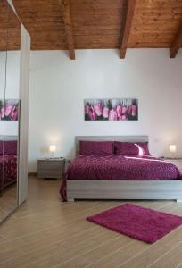 a bedroom with a purple bed and a mirror at IL Casale Di Gio in Naples