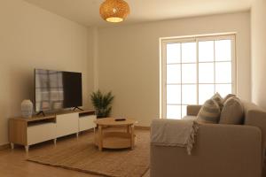 sala de estar con sofá y TV de pantalla plana en Apartamento Formosa Mar by YHA en Cabanas de Tavira