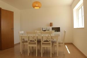 una sala da pranzo con tavolo e sedie di Apartamento Formosa Mar by YHA a Cabanas de Tavira