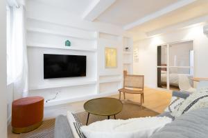 ein Wohnzimmer mit einem Sofa und einem TV an der Wand in der Unterkunft T3 ** BALCON ** VIEUX PORT ** CENTRE in Marseille