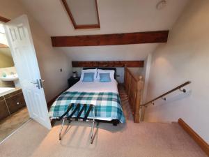 a bedroom with a bed with a checkered blanket at St Ives in Halifax