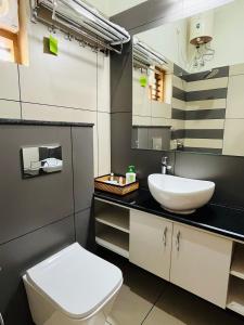a bathroom with a white toilet and a sink at Milaano Orchids, Service Villa, Kammana Mananthavady in Wayanad