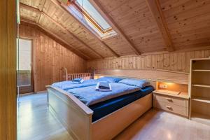 Cama en habitación de madera con tragaluz en Stifterhof App Mathilda en Rio Bianco
