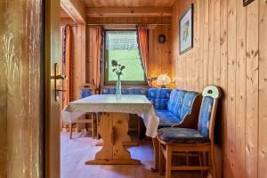 a dining room with a table and a blue couch at Stifterhof App Mathilda in Rio Bianco