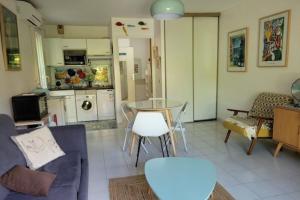 Il comprend un salon avec une table et une cuisine. dans l'établissement Nice studio 30 m with terrace and pool, à Antibes