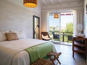 何塞伊格纳西奥Anastasio Hotel & Beach Club的一间带床和阳台的卧室