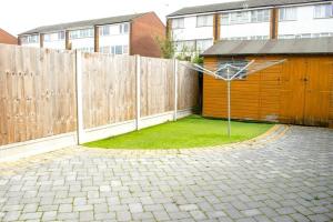 a wooden fence with a basketball hoop in a yard at Spacious 5 bedroom house!Tilbury!Free parking! in Tilbury