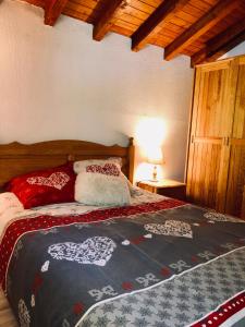 Un dormitorio con una cama con corazones. en Chalet en Haute Savoie Location ski 2 appartements pour 6 ou 8 personnes Saint Gervais Les Bains en Saint-Gervais-les-Bains