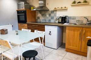 a kitchen with a white table and a white refrigerator at The LouHaiZi #DZ in Seyssinet-Pariset