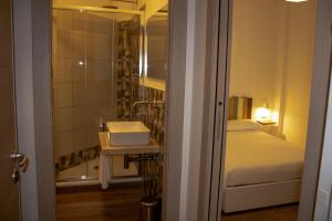 a bedroom with a bed and a bathroom with a sink at B&B JONIO Roma in Rome +47 photos