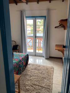 a living room with a couch and a sliding glass door at Casa aconchegante em bairro nobre da cidade Paraty in Paraty