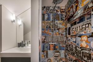 a bathroom with a wall covered in comics at Artsy Exclusive Old Town Residence Gallery Walk in Vilnius +25 photos