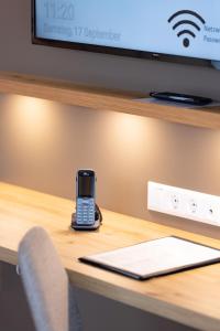 a cell phone sitting on a desk with a laptop at Hotel Restaurant Zur Linde in Erbach