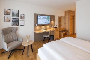 una camera con letto, sedia e scrivania di Hotel Restaurant Zur Linde a Erbach