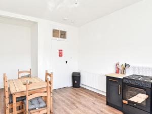 a kitchen with a table and a stove and a dining room at John Muir Apartment in Helensburgh