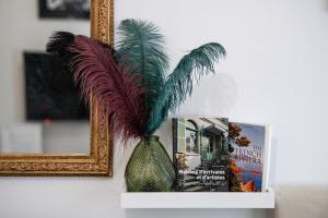 een vaas met een plant er naast een spiegel bij Le Gatsby Superbe cocon cosy proche place in Lyon