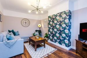 a living room with a blue couch and a table at Open Plan - 3 Bedroom House - Garden and Outdoor Seating - Driveway Parking - Short Drive to City Centre in Saughall