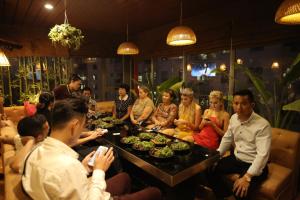 a group of people sitting around a table with food at Kawasaki Hotel Cầu Giấy in Hanoi