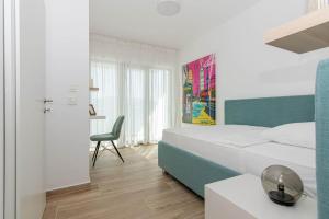a bedroom with a bed and a desk and a chair at Bliss on the Bay in Njivice