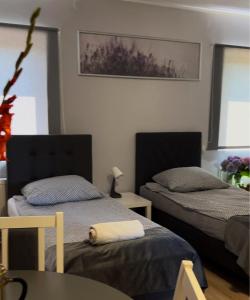 1 dormitorio con 2 camas y mesa en Apartament Adabet en Kępno