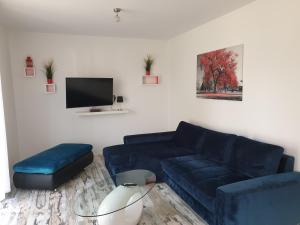 a living room with a blue couch and a tv at Ferienwohnung mit Terrasse in Neustrelitz