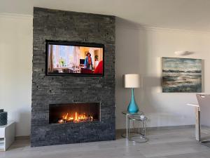 a living room with a fireplace with a tv above it at Vila Sol, Apartment 468 in Quarteira