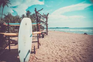 a surfboard is standing on the beach at Infinity of Sri Lanka in Paiyagala South