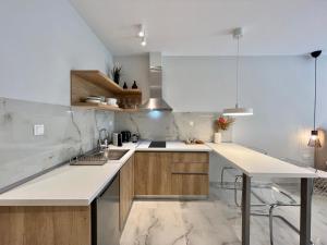 une cuisine avec un comptoir blanc et des placards en bois dans l'établissement Kono Studios & Suites, à Thessalonique