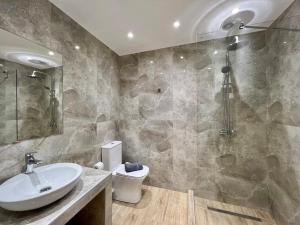 La salle de bains est pourvue d'un lavabo, d'une douche et de toilettes. dans l'établissement Kono Studios & Suites, à Thessalonique