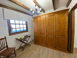 um quarto com armários de madeira, uma cadeira e uma janela em Apartamento Vilaflor em Vilaflor